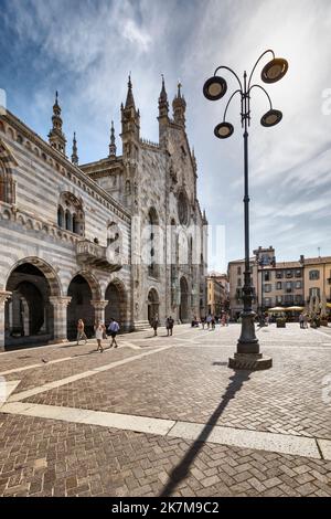 Hauptfassade der Kathedrale im gotischen Stil an einem sonnigen Tag. Menschen überqueren die Piazza del Duomo vor sich. Bild mit hohem Dynamikbereich. Stockfoto