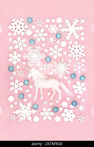 Mythische Weihnachten Einhorn, Schneeflocke und Baumbaudel Dekorationen Hintergrund auf rosa. Fantasy Nordpol Design für Winter, Weihnachten und Neujahr. Stockfoto