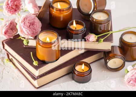 Ein Set verschiedener Duftkerzen in braunen Glasgefäßen. Handgemachte Duftkerze. Sojalkerzen brennen in einem Glas. Aromatherapie und entspannen Sie sich im Spa und zu Hause. Feuer in braunem Glas. Stockfoto