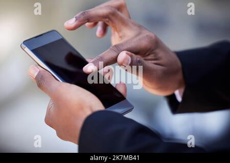 Sie haben die Welt an Ihren Fingerspitzen. Ein nicht erkennbarer Geschäftsmann, der in der Stadt ein Telefon benutzt. Stockfoto