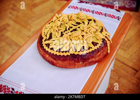 Hochzeitbrot - Brot (Kuchen). Hochzeitsbrot. Ein Laib ist mit Blumen, Ställen, Teigohren geschmückt. Hochzeit. Braut und Bräutigam. Ukrainische Tradition Stockfoto