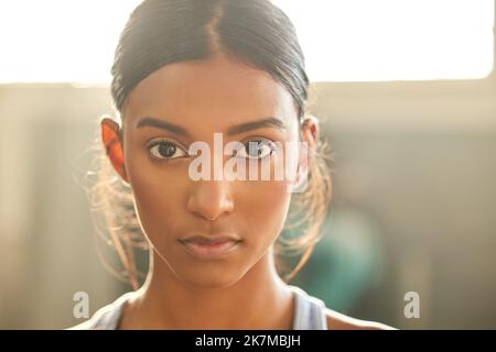 Stellen Sie sich Ihren Fitnesszielen ins Auge. Porträt einer fittenden jungen Frau, die in einem Fitnessstudio arbeitet. Stockfoto