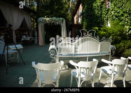 Hochzeitszeremonie. Sehr schöner und stilvoller Hochzeitbogen, geschmückt mit verschiedenen frischen Blumen, im Garten stehend. Hochzeitstag. Frische Blumen de Stockfoto