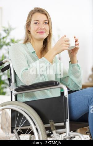Kaffee trinken Behinderte Frau im Rollstuhl Stockfoto