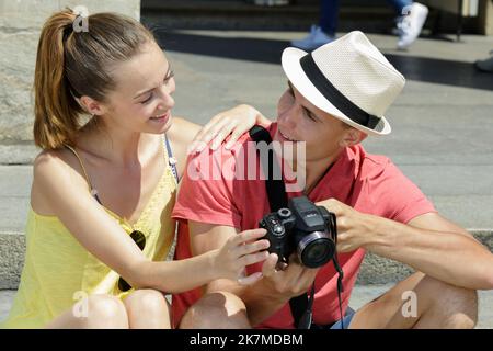 Junges Paar beim Auschecken von Fotos auf der Kamera Stockfoto