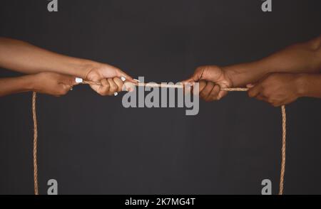 Tauziehen, Mann und Frau ziehen für Opposition, Macht und Ungleichheit in der Wirtschaft an einem Seil in die entgegengesetzte Richtung. Wettbewerb und Herausforderung mit Menschen Stockfoto