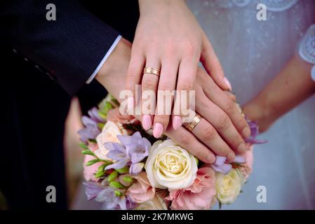 Die Braut hält einen Brautstrauß aus Rosen in den Händen, Hochzeitstag Blumen. Schöner Bohemian Hochzeit Blumenstrauß. Mädchen in einem Kleid mit einem Bouq Stockfoto