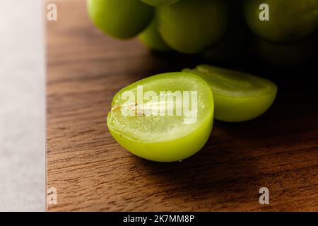 Eine Vielzahl von grünen Trauben. Runde süße Früchte. Japanische GourmetA Sorte von süßgrünen Trauben, Shine MuscataA Sorte von süßgrünen Trauben, Shine Muscat Stockfoto