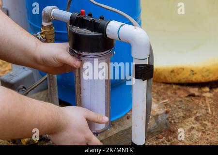 Ersetzen Sie die austauschbaren Filter für die Reinigung von Wasser in der Nähe von zu Hause durch professionelle Mitarbeiter, die Wartungsarbeiten durchführen, und ersetzen Sie die austauschbaren Filter in den Außenbereichen des Hauses Stockfoto