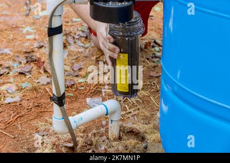 Die Wartung wird von professionellen Mitarbeitern durchgeführt, die austauschbare Filter für die Reinigung des Wassers in der Nähe von zu Hause ersetzen Stockfoto