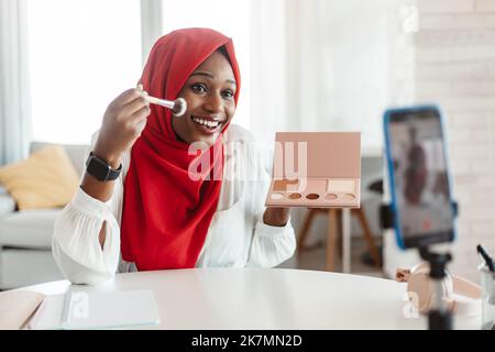 Beauty Blogging. Schwarze islamische Influencer Dame, die Make-up Review aufzeichnet, Rouge anwendet und Videos für ihren Blog aufzeichnet Stockfoto