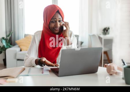 Problemkonzept. Frustrierte schwarze muslimische Frau, die am Handy spricht und einen Laptop benutzt, Probleme hat Stockfoto