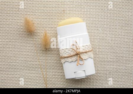 Hausgemachter Deodorant-Stick mit allen natürlichen Zutaten Konzept. Flache Ansicht des Nachfüllbehälters mit natürlichem Antitranspirant auf natürlichem Textil. Stockfoto