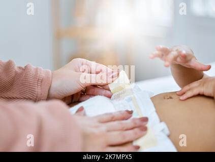 Eine gute Windel macht den Unterschied. Eine Mutter wechselt ihre Babywindel. Stockfoto