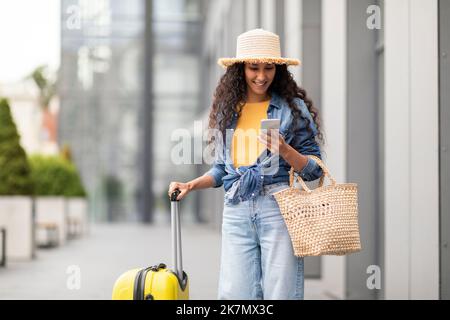 Frau mit Smartphone in der Hand, die beim Flughafen steht Stockfoto