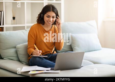 Online-Schulungen. Junge Arabische Frau Im Headset Studie Mit Laptop Zu Hause Stockfoto