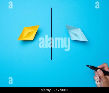 Zwei Papierboote und eine Linie mit einem Marker dazwischen. Abstimmungs-Konzept, Konflikt stoppen Stockfoto