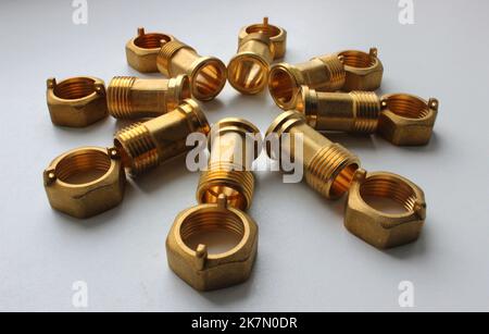 Messing-Armaturen Und Verbindungsmuttern In Form Von Blume Auf Weißer Oberfläche Stockfoto