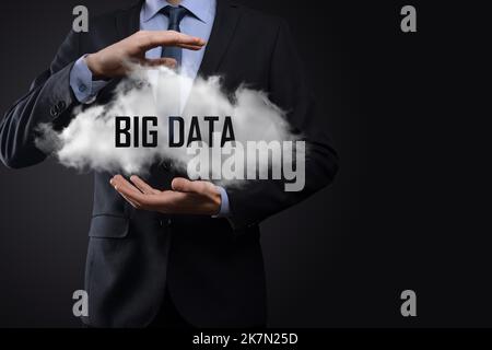 Eine Hand zeigt eine Wolke mit den Worten Big Data auf dunklem Hintergrund Stockfoto