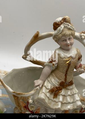 Eine Vintage-Porzellanfigur des Mädchens durch den Brunnen, vertikale Aufnahme Stockfoto