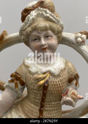 Eine Vintage-Porzellanfigur des Mädchens durch den Brunnen, vertikale Aufnahme Stockfoto