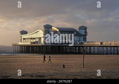 Menschen, die an einem Herbstabend am Strand von Weston Super Mare Sport treiben. Stockfoto