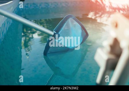 Reinigung des Swimmingpools. Reinigungsgeräte für Schwimmbäder, sonniger Tag Stockfoto