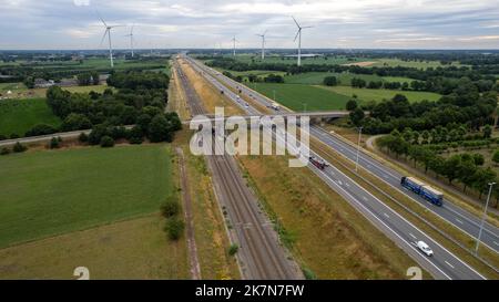 Brecht, Belgien, 6.. Juli 2022, Panorama-Drohnenansicht von Windpark oder Windpark, mit hohen Windkraftanlagen zur Stromerzeugung mit der Autobahn mit wenigen Autos und Eisenbahn daneben, in der Nähe der Ausfahrt von Brecht in Belgien, Europa. Hochwertige Fotos Stockfoto