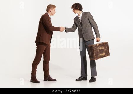 Guter Deal, Gruß. Zwei Personen in Anzügen begrüßen sich in traditionellem Händedruck, isoliert auf weißem Studiohintergrund. Geschäftskonzept, Meeting Stockfoto