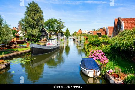 Malerische, traditionelle, rote Ziegeldächer an einem Wasserkanal in Edam, Nordholland, Niederlande Stockfoto