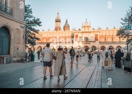 Krakau, Polen - 25. August 2022: St. Marienbasilika auf dem Hauptplatz von Krakau. Wawel Castle. Touristen gehen im Sommer durch das Stadtzentrum Stockfoto