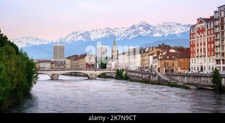 Grenoble, Frankreich, Panoramablick auf das historische Stadtzentrum mit dem Fluss Isere und schneebedeckten französischen Alpen bei Sonnenuntergang Stockfoto