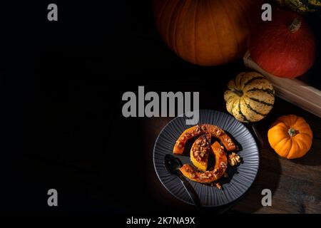 Dunkel launisch bildlich Stillleben von Herbst gerösteten Butternut Kürbis mit Zimt, Walnüssen und Honig bestäubt Stockfoto