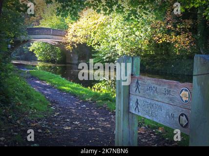 Bridgewater Canal und Towpath an der Grappenhall Bridge, Grappenhall Village, South Warrington, Ceshire, England, UK Wegweiser zu Lymm & Stockton Heath Stockfoto