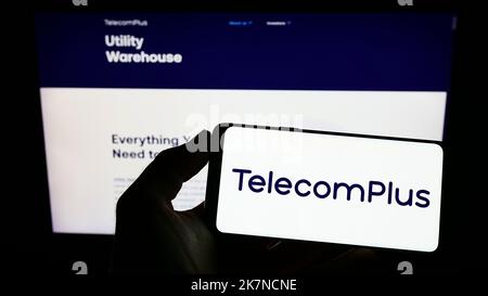 Person, die das Smartphone mit dem Logo der britischen Firma Telecom Plus plc auf dem Bildschirm vor der Website hält. Konzentrieren Sie sich auf die Telefonanzeige. Stockfoto