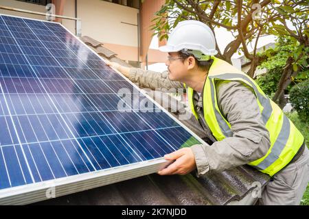 Blue Solar Photo Voltaic Paneele System von Wohngebäude an sonnigen Tag. Erneuerbare ökologische grüne Energie. Wartungspaneele sammeln Sonnenenergie. Stockfoto