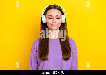 Foto von niedlichen schönen ruhigen Dame tragen violette Outfit genießen moderne Qualität Sound Accessoire Lieblings-Sänger isoliert auf gelbem Hintergrund Stockfoto