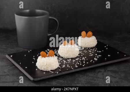 Köstliches Dessert cremiger Souffle, dekoriert mit Kokosnusschips und Nüssen auf dunklem Hintergrund Stockfoto
