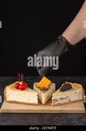 Klassischer Käsekuchen mit Kirschen auf dunklem Hintergrund. Stockfoto