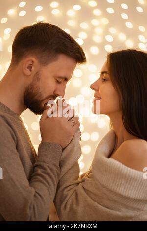 Zwei fröhlich schön süß zart schön liebenswert niedlich romantisch verheiratet Ehepartner Ehemann und Ehefrau suchen einander mit Licht Im Hintergrund Stockfoto