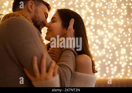 Zwei schöne süße zarte schöne liebenswert niedlichen romantischen Paar in einem Snood feiern Liebe und küssen auf Lichter Hintergrund Stockfoto