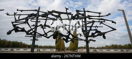 Dachau, Deutschland. 18. Oktober 2022. Die Bronzeskulptur 'Menschen im Stacheldraht' steht auf dem apellplatz des ehemaligen Konzentrationslagers. Das Denkmal, das der Künstler Nandor Glid 1967 geschaffen hat, wurde nach mehr als drei Jahren Restaurierung neu eingeweiht. Quelle: Stefan Puchner/dpa/Alamy Live News Stockfoto