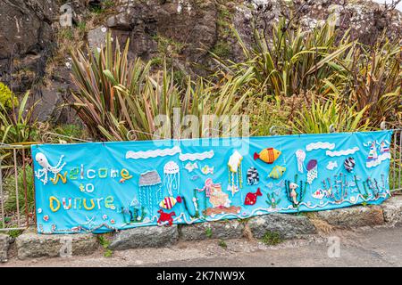 Ein handgemachtes Banner im Hafen, das Besucher des Küstendorfes Dunure, South Ayrshire, Schottland, willkommen heißt Stockfoto