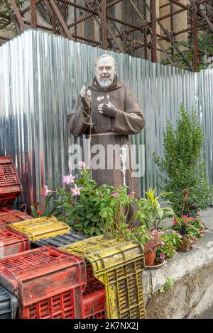 Sizilien, Italien - 26. September 2022: Statue von Padre Pio auf Sizilien auf einer Baustelle. Blumen und Flaschenhalter vorne. Stockfoto