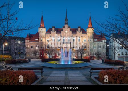 Walbrzych, Polen. Blick auf den Plac Magistracki Platz in der Abenddämmerung mit beleuchtetem Gebäude des Rathauses Stockfoto