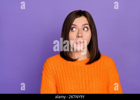 Foto-Porträt von wunderschönen jungen Frau aussehen leeren Raum lecken Lippen gekleidet stilvolle gestrickt orange Outfit isoliert auf lila Farbe Hintergrund Stockfoto