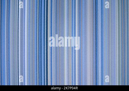 Farbenfroher, blauer Stoffhintergrund mit weichen verblassten, regenbogenfarbenen vertikalen Streifen Stockfoto