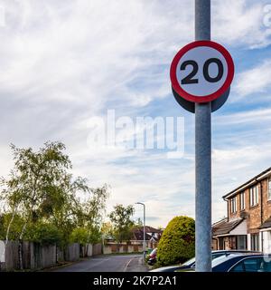 Detailansicht eines britischen 20MPH-Straßengeschwindigkeitsbegrenzungszeichens in einer ruhigen Vorstadtstraße. Aufgrund der Politik der walisischen Regierung. Stockfoto