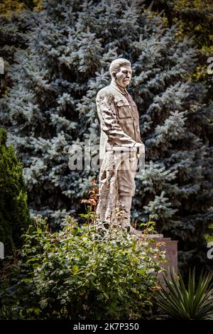 2019 07 20 Gori Georgia - Marmorstatue des Diktators Joseph Stalin im Garten des Museums über seinem Geburtsort erbaut - Blaue Fichte hinter Statue ist blu Stockfoto