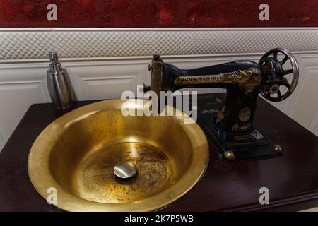 Grodno, Weißrussland - 13. Oktober 2017: Ein Waschbecken aus einer alten Singer Nähmaschine in der Faraday Bar. Das Wasser schaltet sich automatisch ein, wenn die h Stockfoto